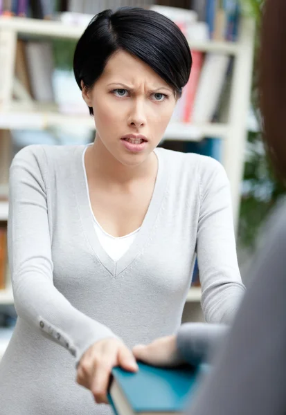 Boos meisje probeert weg te nemen het boek — Stockfoto