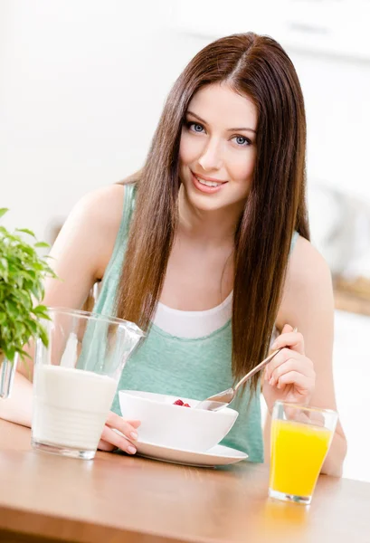 Menina comendo cereais saudáveis e suco de laranja — Fotografia de Stock