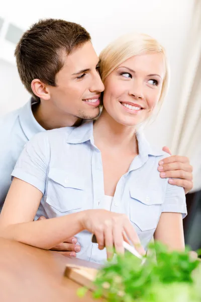 Uomo abbraccia ragazza mentre lei sta cucinando — Foto Stock