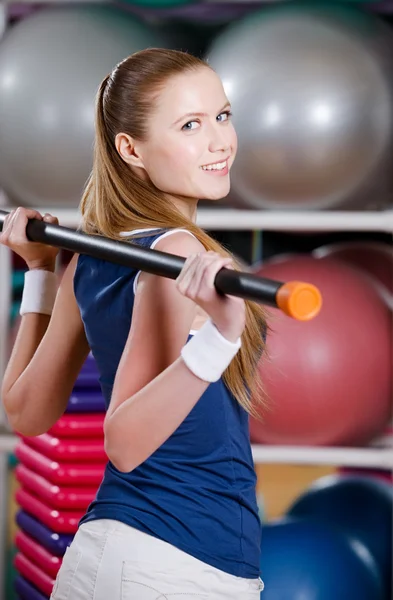 Mulher esportiva trabalha com vara de ginástica — Fotografia de Stock