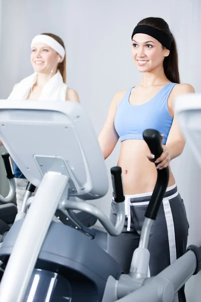 两个妇女在模拟器在健身房训练 — 图库照片