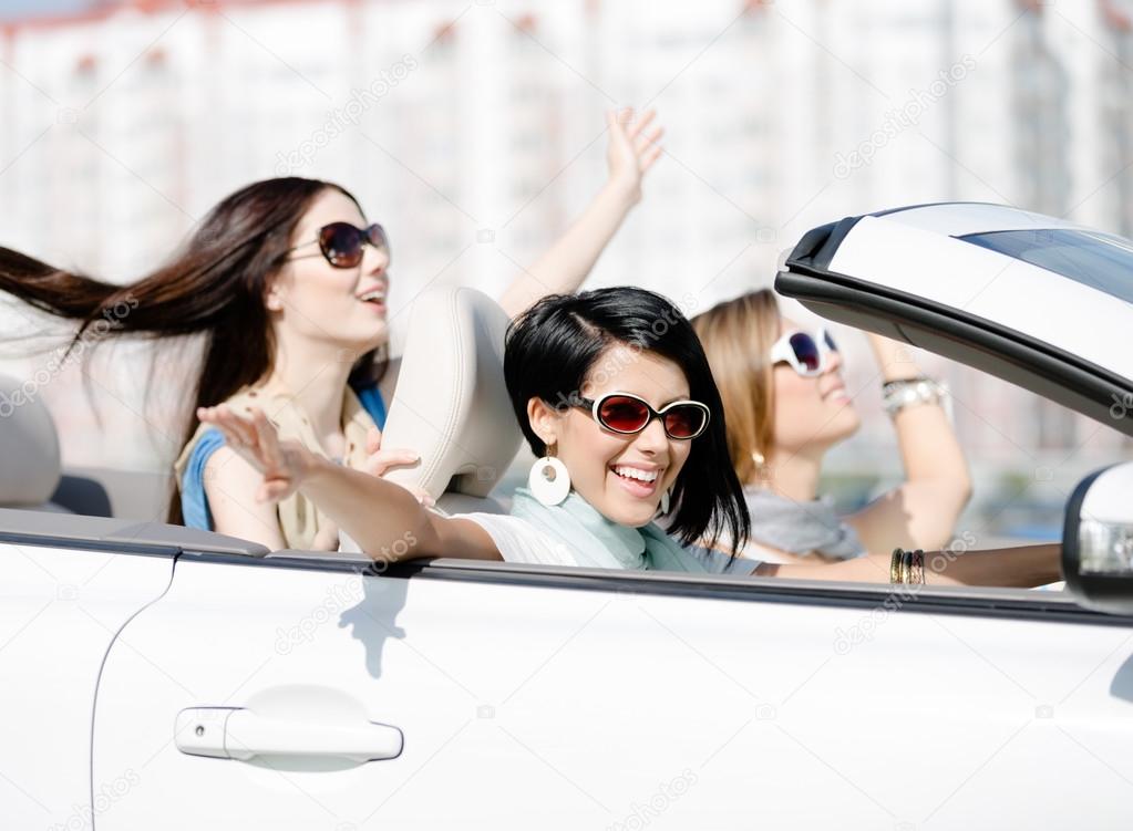 Group of girls with outstretched arms in the car