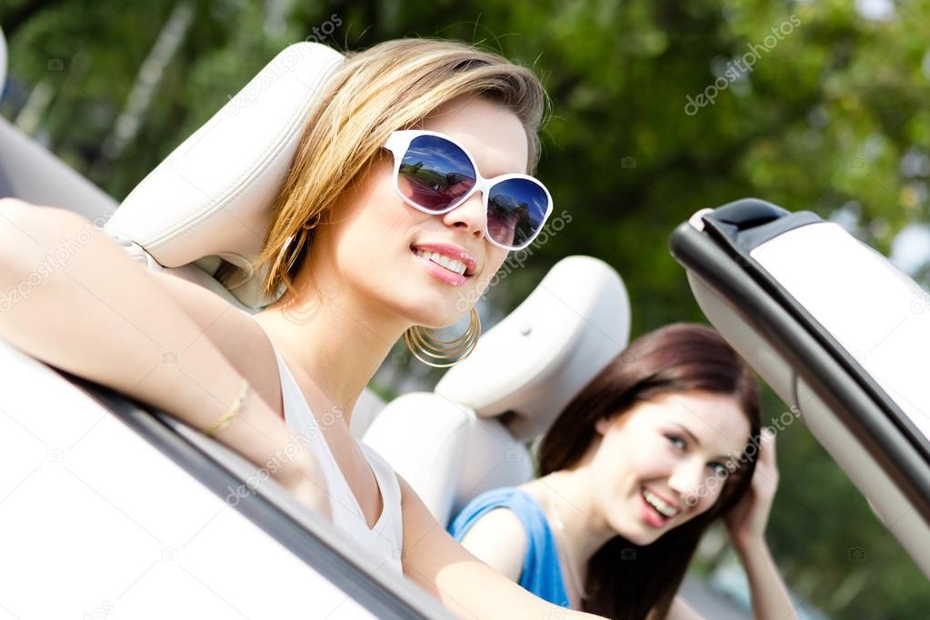 Two girls ride the cabriolet
