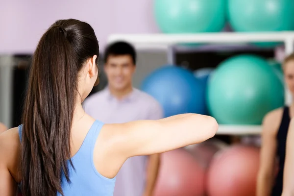 Young coach shows new exercises — Stock Photo, Image