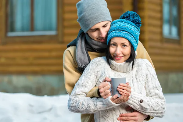 Embracing couple drinking tea outdoors — Stock Photo, Image