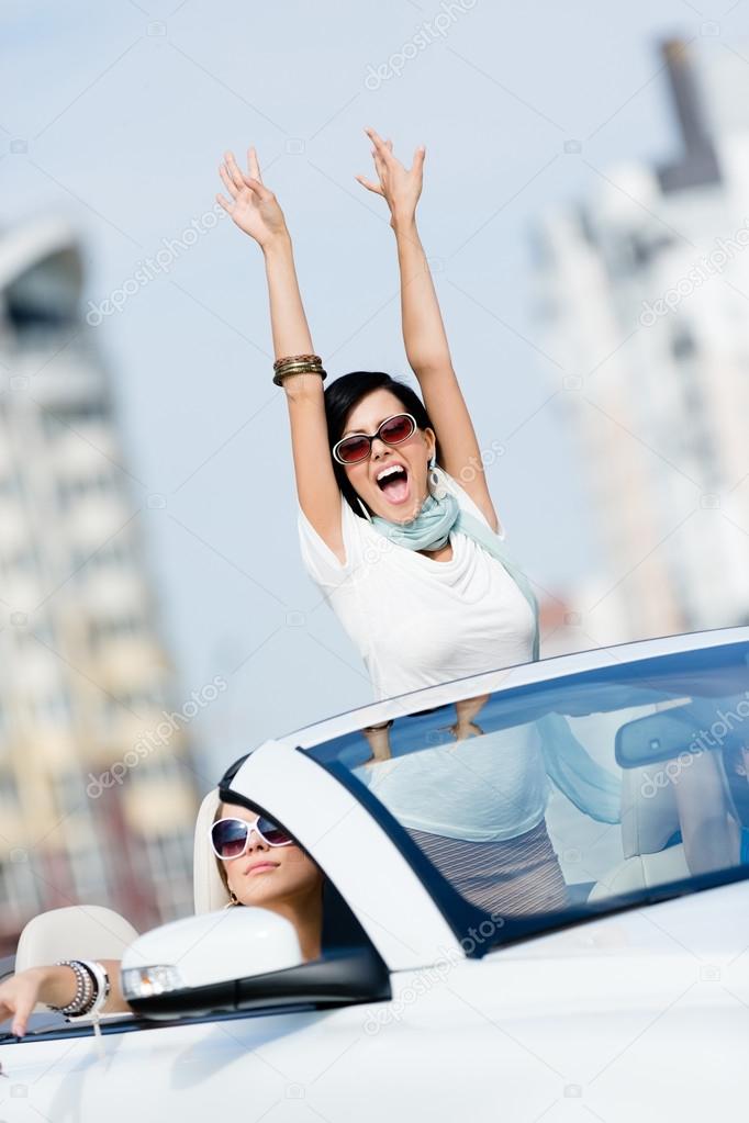 Lovely teenager with her hands up in the car