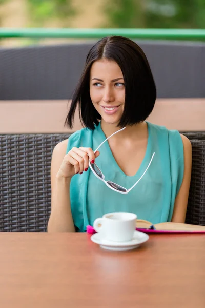 Pensive girl sits at the cafe with cup of tea — Stock Photo, Image