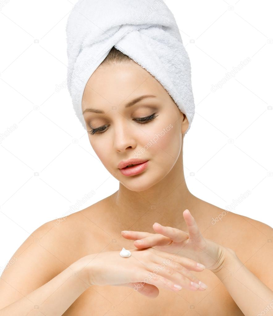 Sexy girl with towel on head applies cream