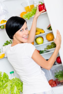 kadın biber açılan buzdolabından alır.