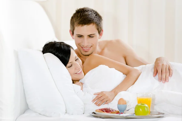 Hombre sirve desayuno de mujer en el dormitorio — Foto de Stock