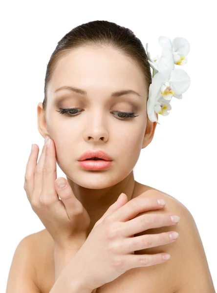 Nude girl with orchid in hair touches her face — Stock Photo, Image