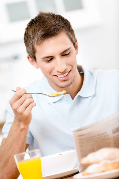 Reading male eats dieting breakfast in kitchen — Stock Photo, Image