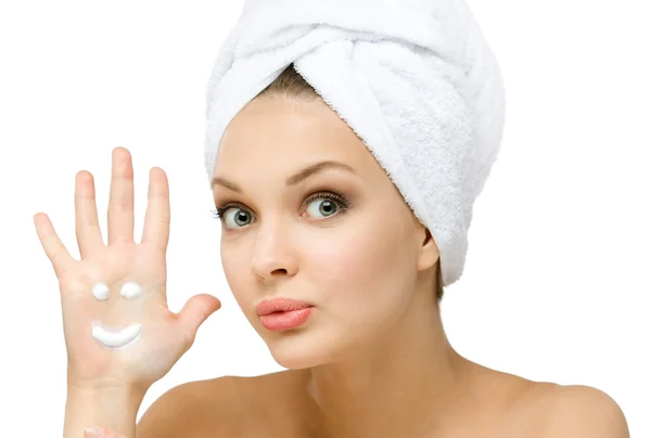 Girl with towel on head shows cream smiley on palm — Stock Photo, Image