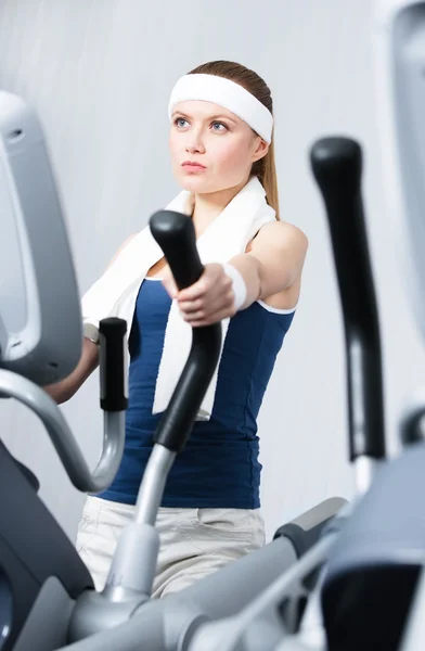 Idrottsman kvinna utbildning på simulatorer i gym — Stockfoto