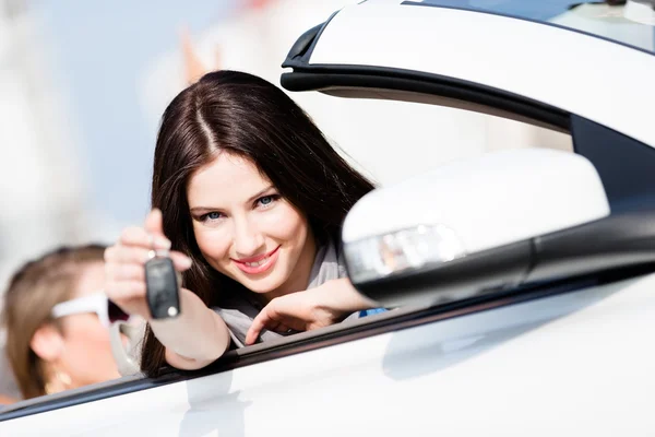 Chica en el coche muestra la llave del coche — Foto de Stock