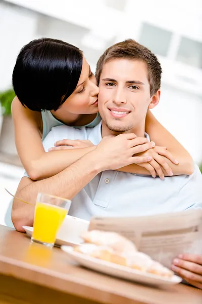 Женщина целует съедающего парня — стоковое фото