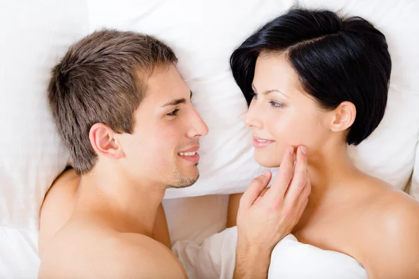 Close up of man stroking woman lying in bedroom — Stock Photo, Image