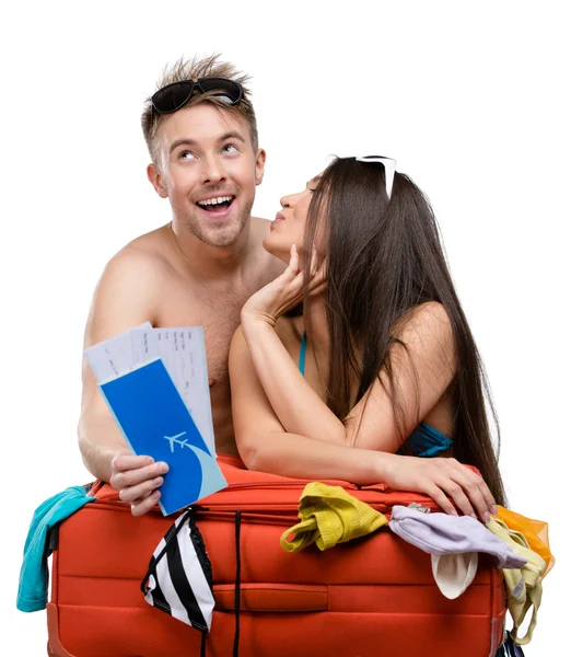 Couple packs suitcase and tries on clothing for traveling — Stock Photo, Image