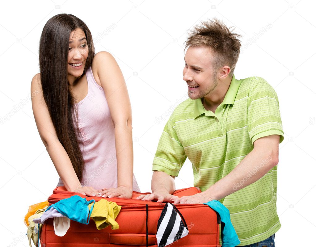 Couple packs up suitcase with clothing for journey
