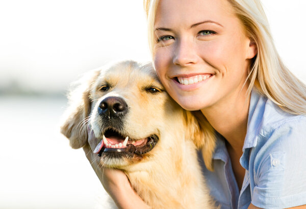 Close up of woman embracing golden retriever