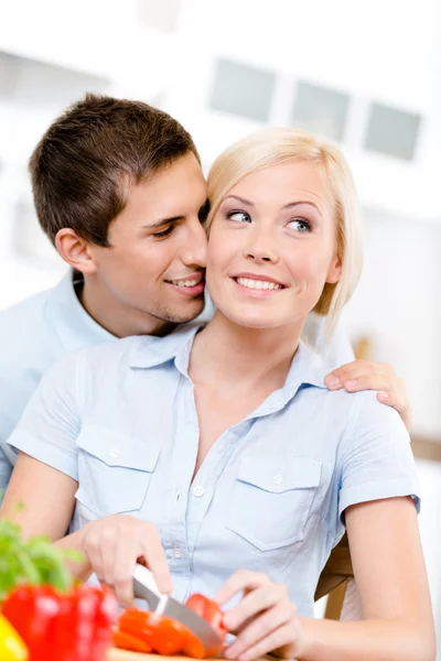 Man kisses lady while she is cooking — Stock Photo, Image