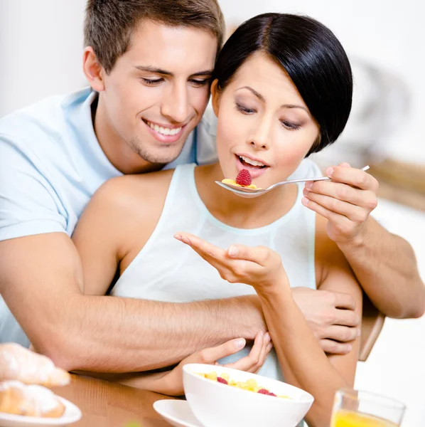 Young man feeds and embraces his girlfriend — Stock Image Young man feeds and embraces his girlfriend Stock Photo