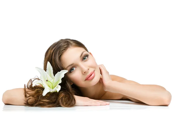 Relaxed girl with lily in hair lies Stock Photo