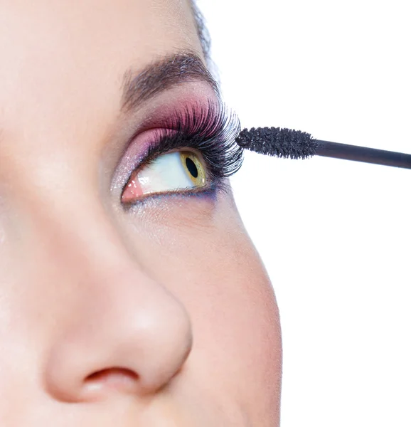 Female eye with bright makeup and brush applying mascara on eyelashes — Stock Photo, Image