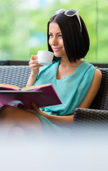 Könyv olvasó lány iszik kávét a bárban — Stock Fotó