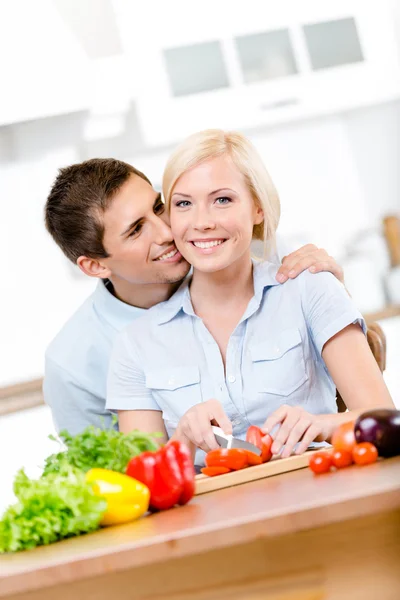 Homme embrasse jolie femme pendant qu'elle cuisine — Photo