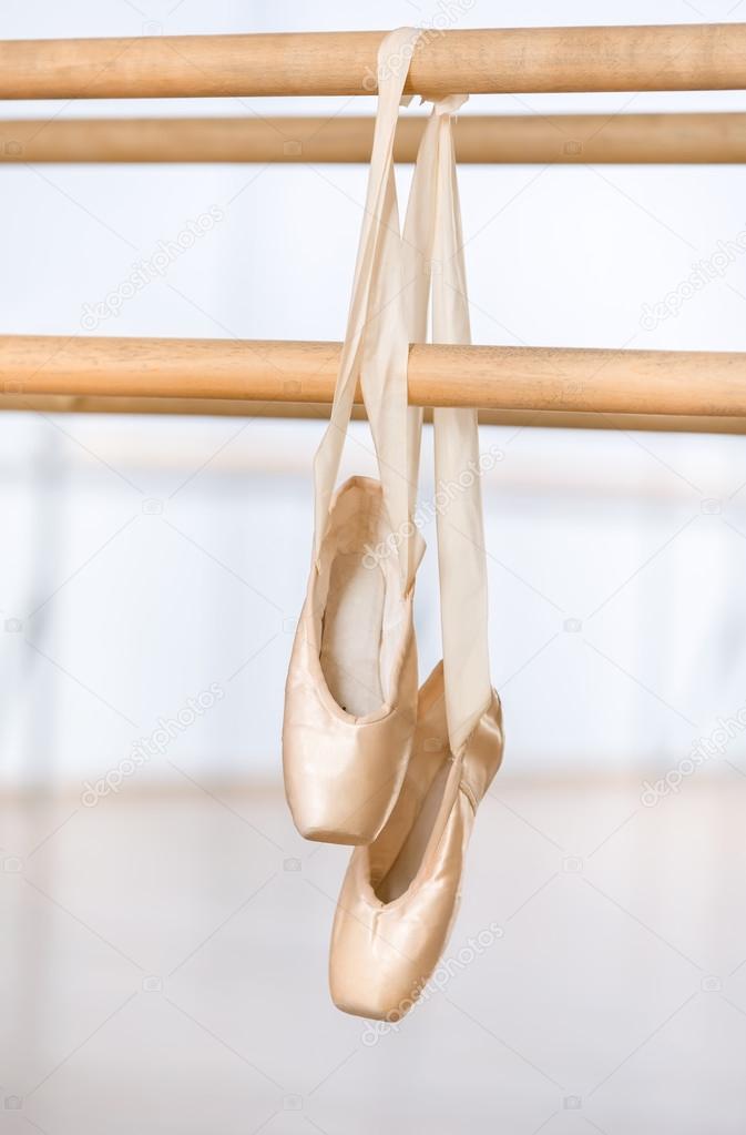Close up view of pointes for ballet hanging on barre