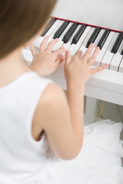 piyano beyaz elbiseli küçük bir çocuk