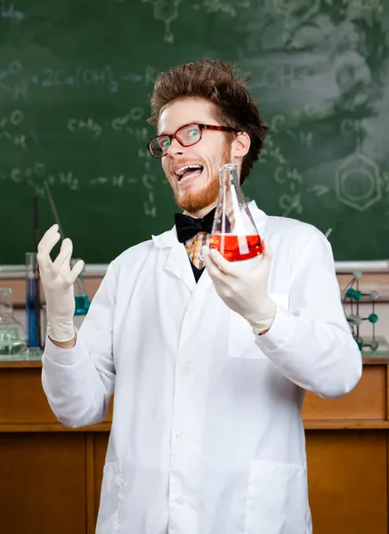 Mad professor laughs handing conical flask — Stock Photo, Image