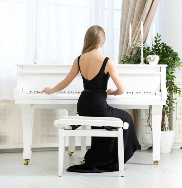 Музыкант сидит и играет на пианино — стоковое фото