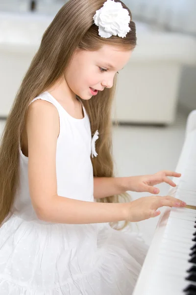 Маленький музыкант играет на пианино — стоковое фото