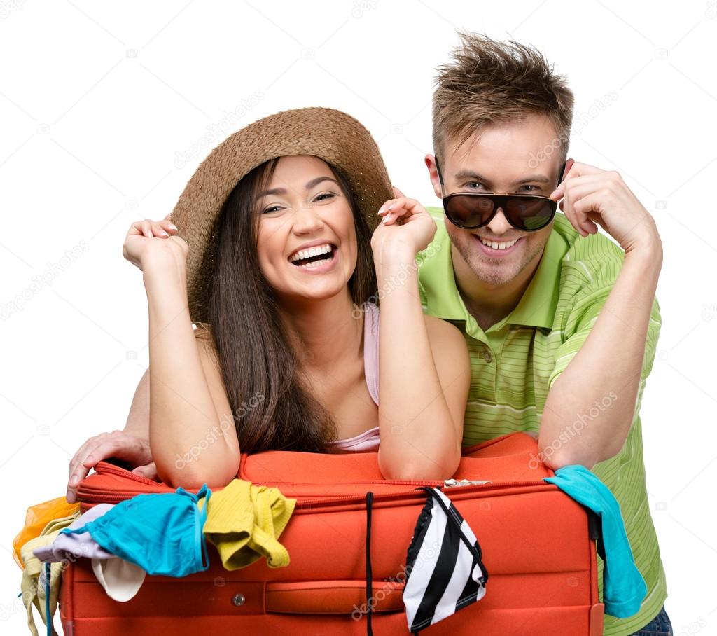 Couple packs up suitcase for traveling