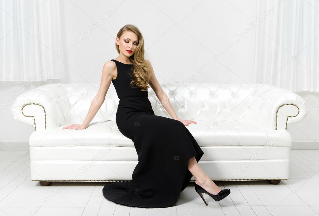 Woman sitting on white leather sofa