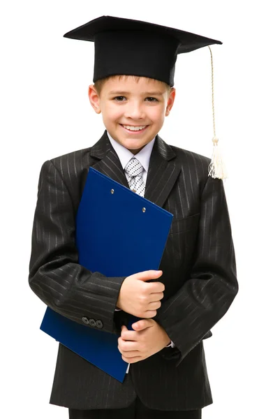 Poco estudiante en la tapa académica mantiene la carpeta — Foto de Stock