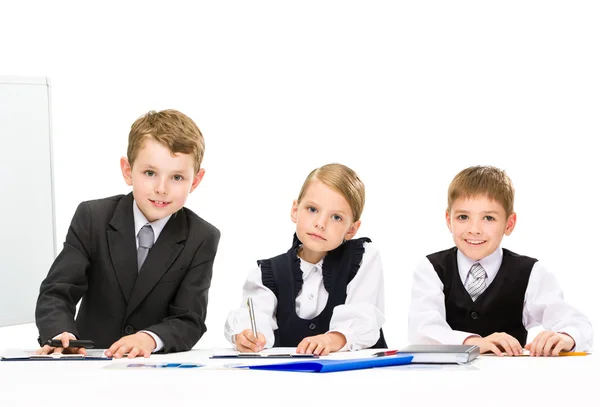 Little business people sitting at the table — Stock Photo, Image