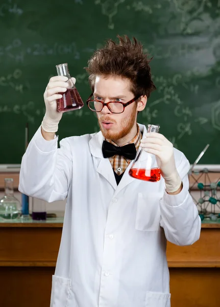Mad professor wonders at the flasks — Stock Photo, Image