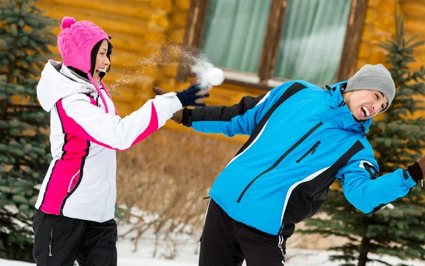 Ungt par spelar på snöbollar och ha roligt — Stockfoto