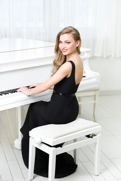 Retrato de mulher sentada e tocando piano — Fotografia de Stock