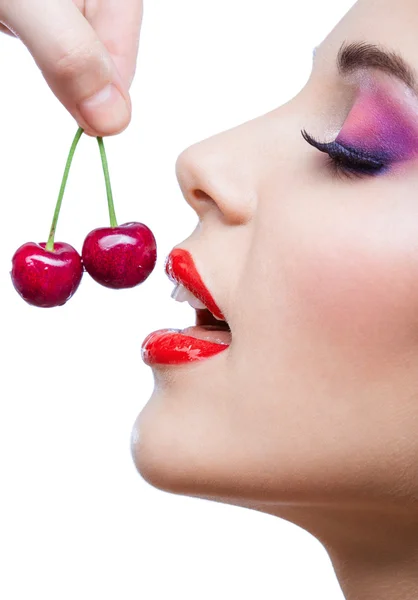 Close up view of woman with red lips eating two berries — Stock Photo, Image