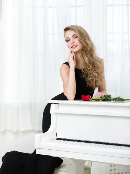 Retrato de una mujer de pie cerca del piano —  Fotos de Stock