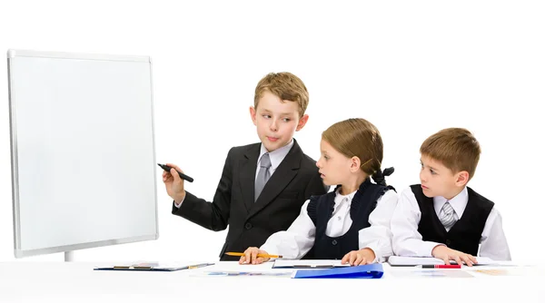 Little businessman showing smth to little business people — Stock Photo, Image