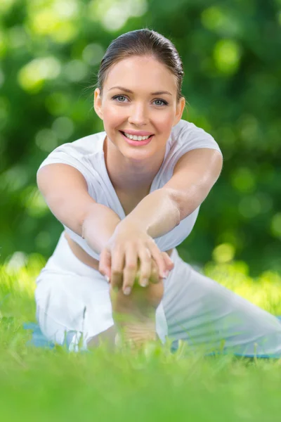 Portrait of sportswoman stretching in park — Stock Photo, Image