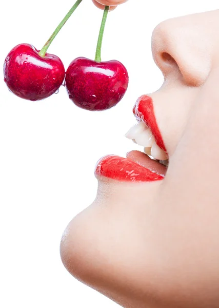 Крупный план девушки с красными губами, поедающей две ягоды — стоковое фото