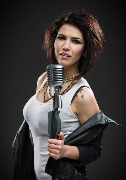 Female rock musician handing microphone — Stock Photo, Image