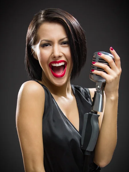 Kadın şarkıcı tutma mic — Stok fotoğraf