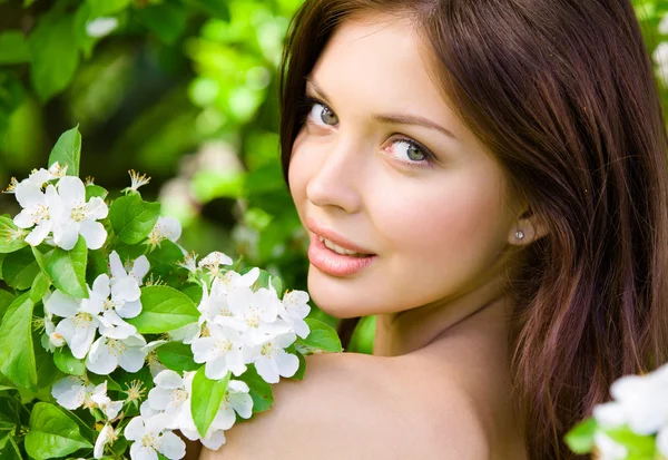 Chica atractiva cerca del árbol florecido — Foto de Stock